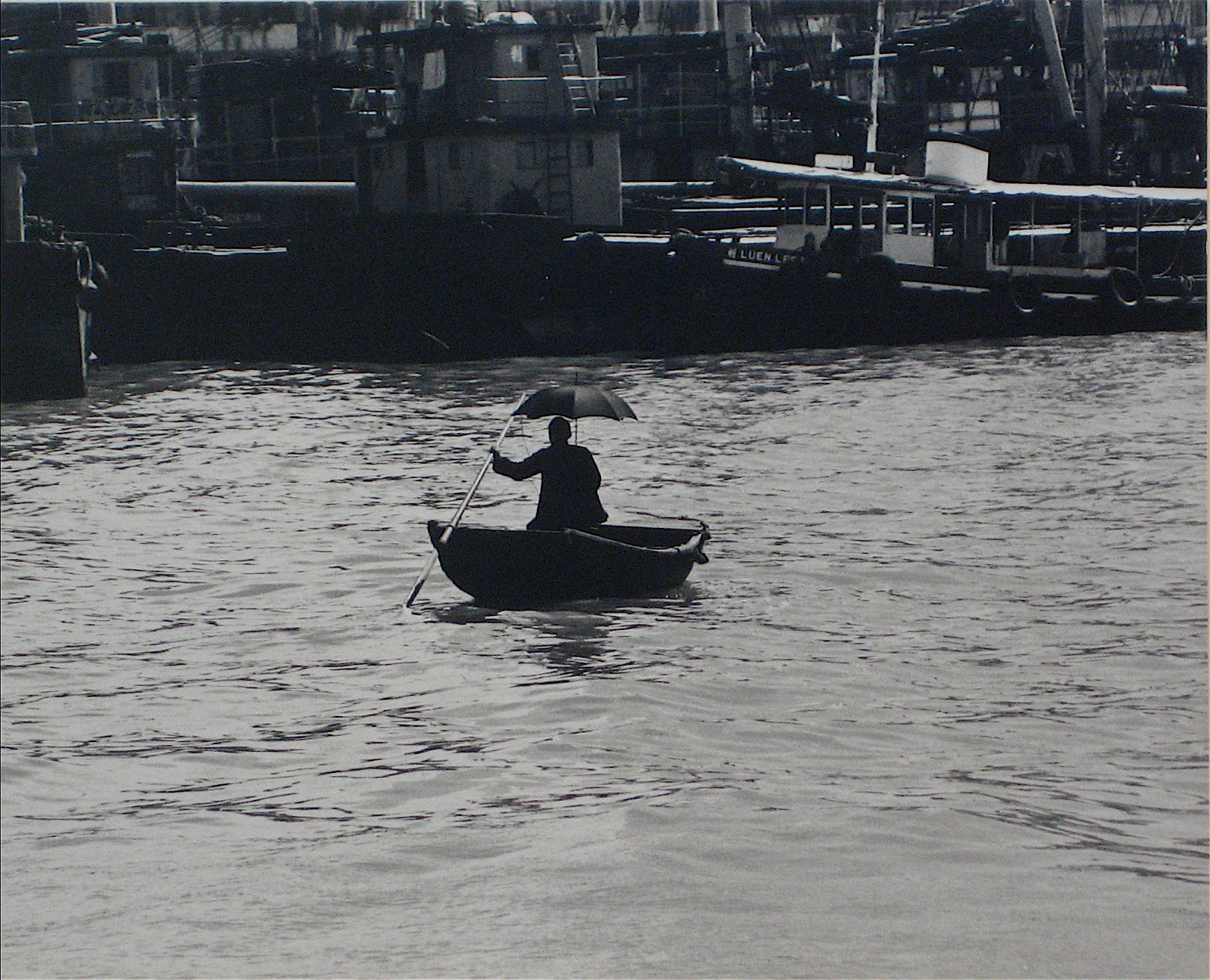 Silhouetted Figure with Umbrella in Canoe <br>1960s Silver Gelatin Print <br><br>#12269